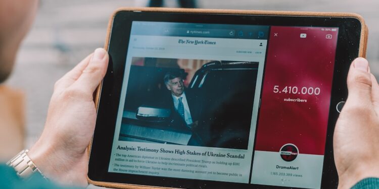 man wearing green long-sleeved shirt using iPad
